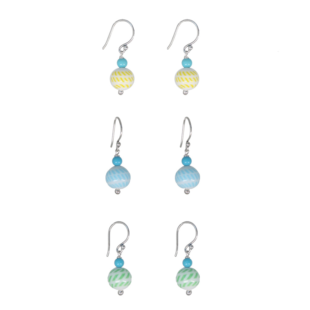Six pairs of dangling earrings arranged in a grid on a plain white background. Each pair has a silver fishhook ear wire, a small turquoise bead, and a larger striped glass bead in yellow, blue, or green.