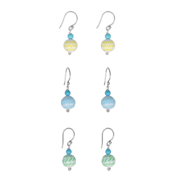 Six pairs of dangling earrings arranged in a grid on a plain white background. Each pair has a silver fishhook ear wire, a small turquoise bead, and a larger striped glass bead in yellow, blue, or green.