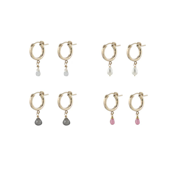 Set of gold hoop earrings with various colored drop pendants on a white background