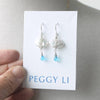 White pearl earrings with a blue stone drop