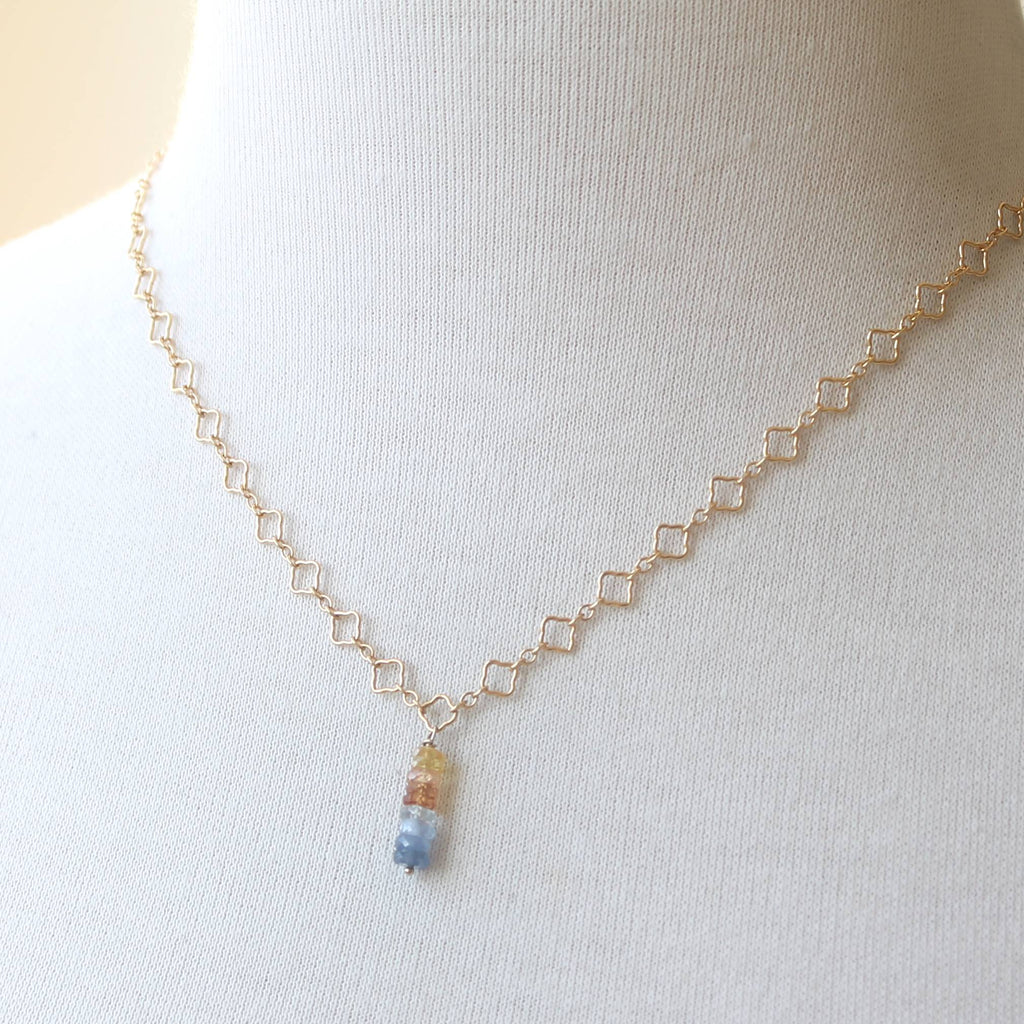 Delicate necklace with a small pendant on a mannequin bust against a white background