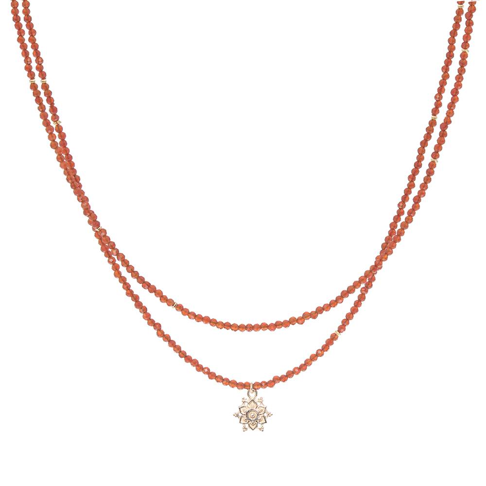 Two layered necklaces with carnelian  beads and a gold flower pendant on a white background