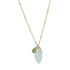 A marquise cut gemstone necklace with a gold or gold-filled chain and multiple gemstones including aqua chalcedony, green vessonite, pink chalcedony, grey hydroquartz, red garnet, and purple amethyst.