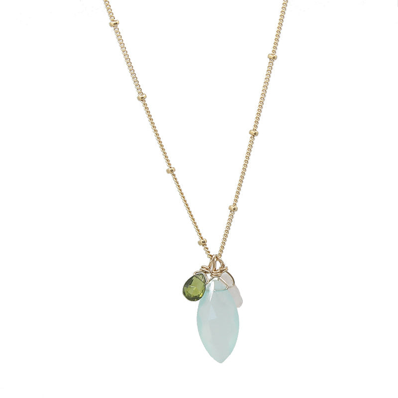 A marquise cut gemstone necklace with a gold or gold-filled chain and multiple gemstones including aqua chalcedony, green vessonite, pink chalcedony, grey hydroquartz, red garnet, and purple amethyst.
