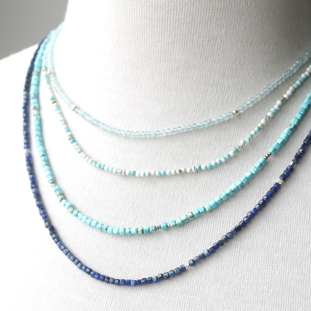 Set of blue and turquoise beaded necklaces on a mannequin.