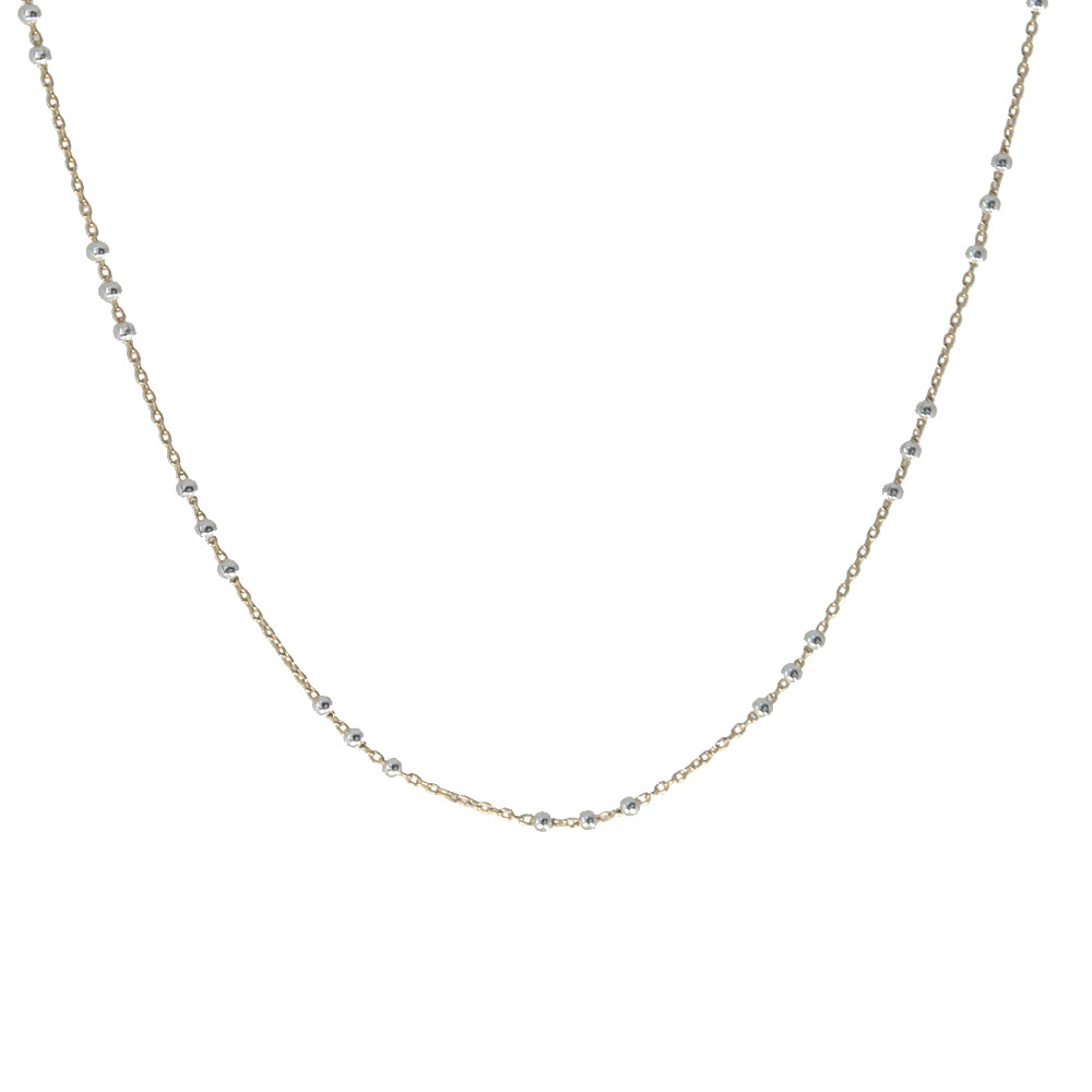 A delicate gold chain necklace with small, evenly spaced silver-toned bead accents, displayed against a solid white background.