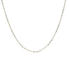 A delicate gold chain necklace with small, evenly spaced silver-toned bead accents, displayed against a solid white background.