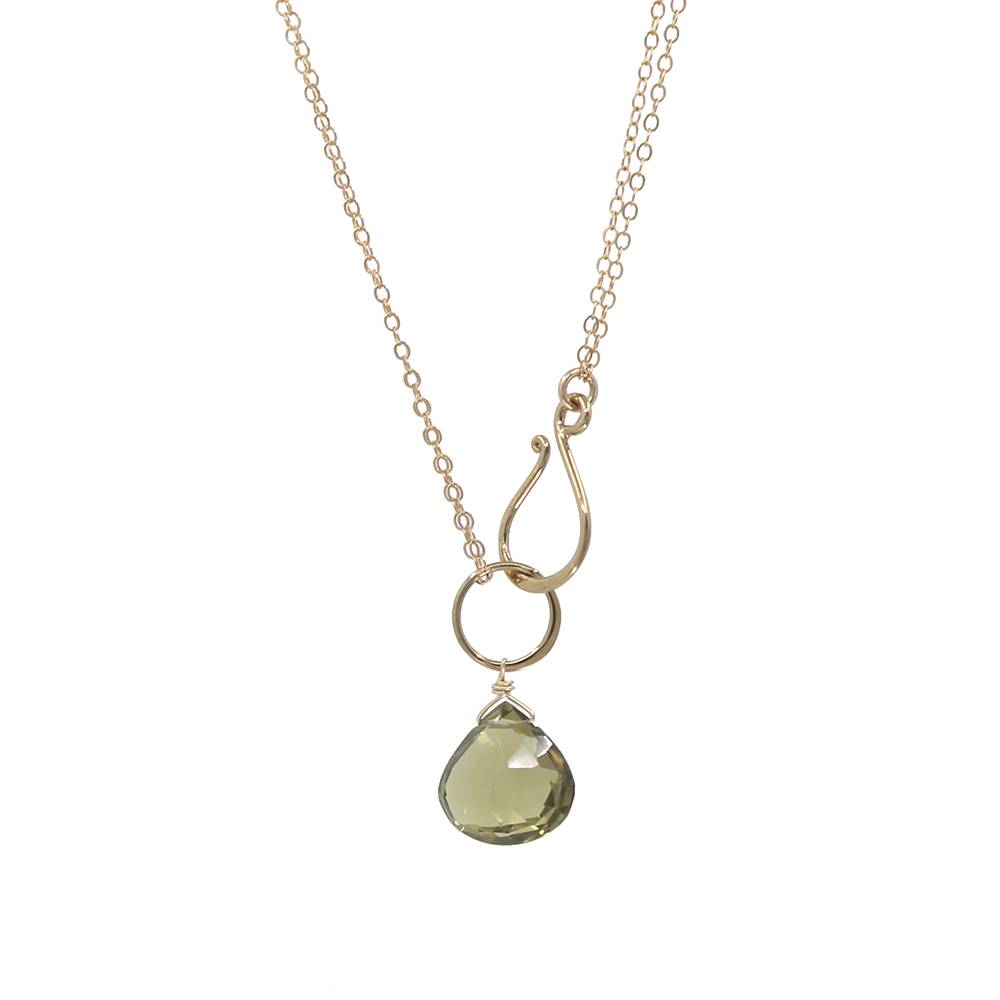 Gold necklace with a green teardrop pendant on a white background