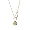 Gold necklace with a green teardrop pendant on a white background