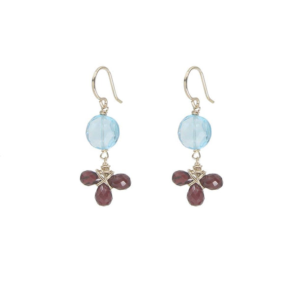 Pair of earrings with blue gemstones and red beads on a white background