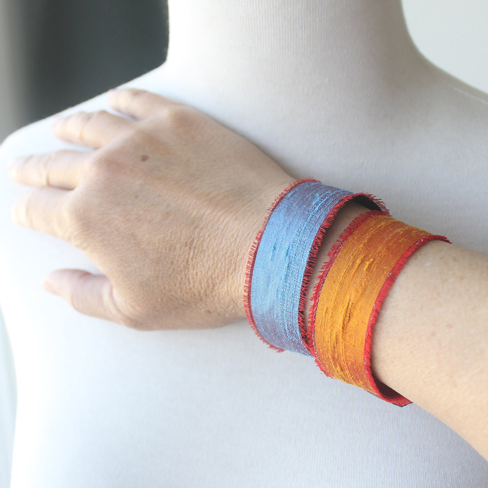 Close-up of a wrist wearing two colorful bracelets 