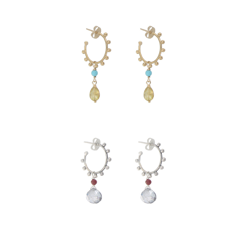 Pair of gold and silver earrings with gemstones on a white background