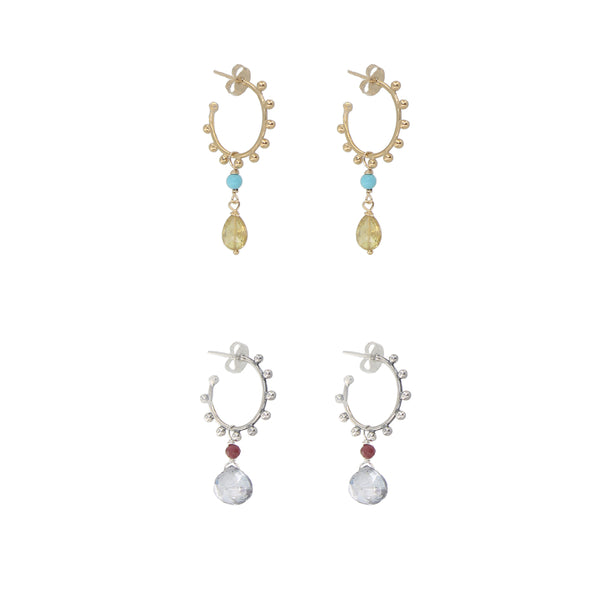 Pair of gold and silver earrings with gemstones on a white background