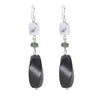 Pair of earrings with black oval beads and white square beads on a white background