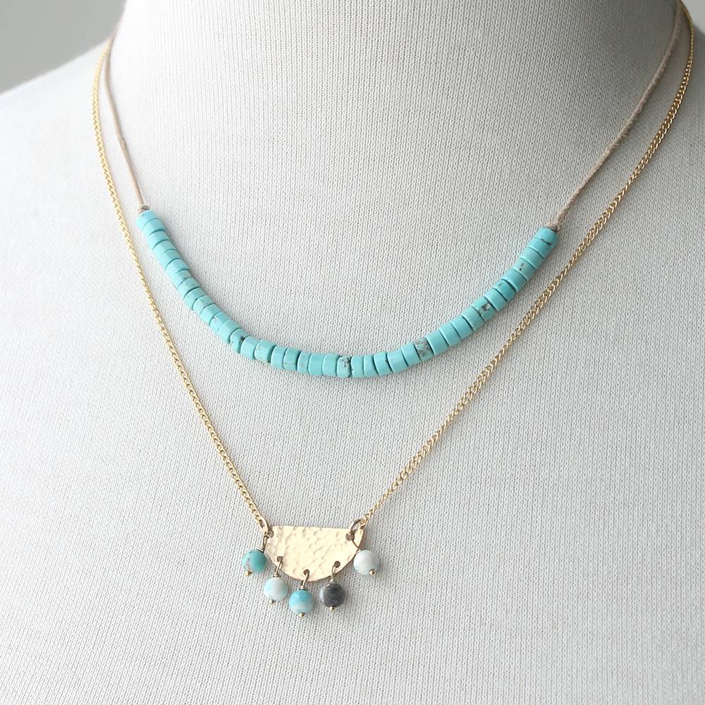 Necklace with turquoise beads and gold chain on a mannequin