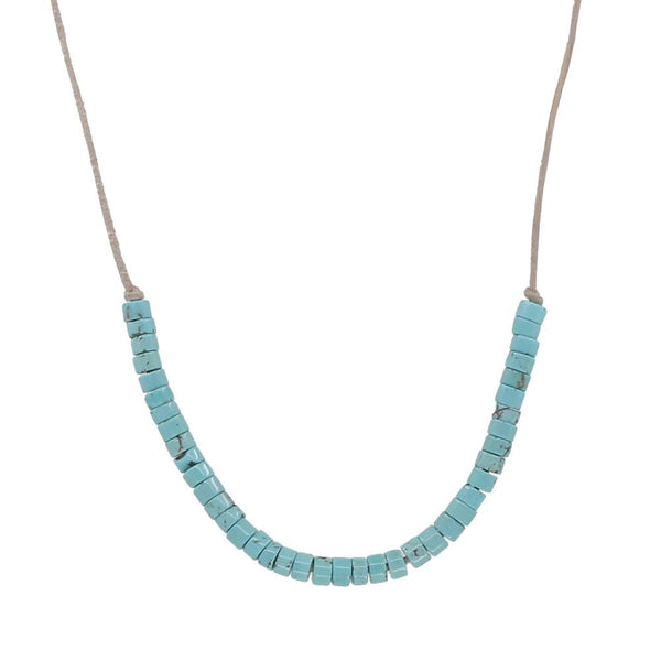 Turquoise beaded necklace on leather cord on a white background