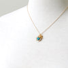Gold bird charm and nest with turquoise eggs necklace