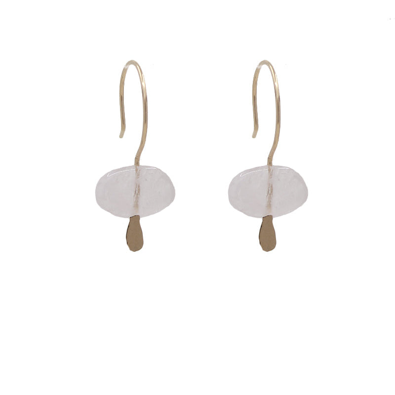 A pair of huggie earrings featuring pale pink morganites attached to gold-colored earwires.